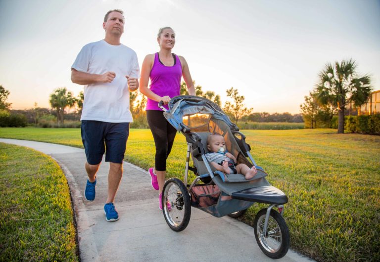 Couple jogging on a path while pushing a baby stroller | The Bear's Den Resort Orlando
