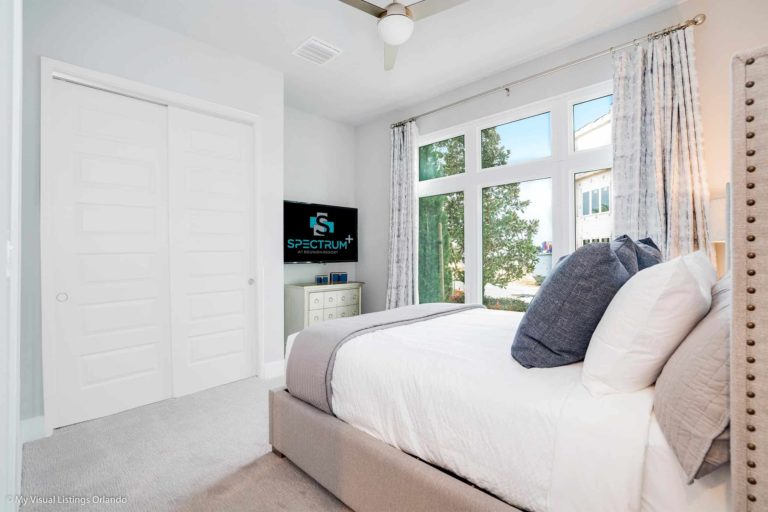 Furnished Bedroom With Tv And Large Window In A Spectrum Resort Orlando Residence.