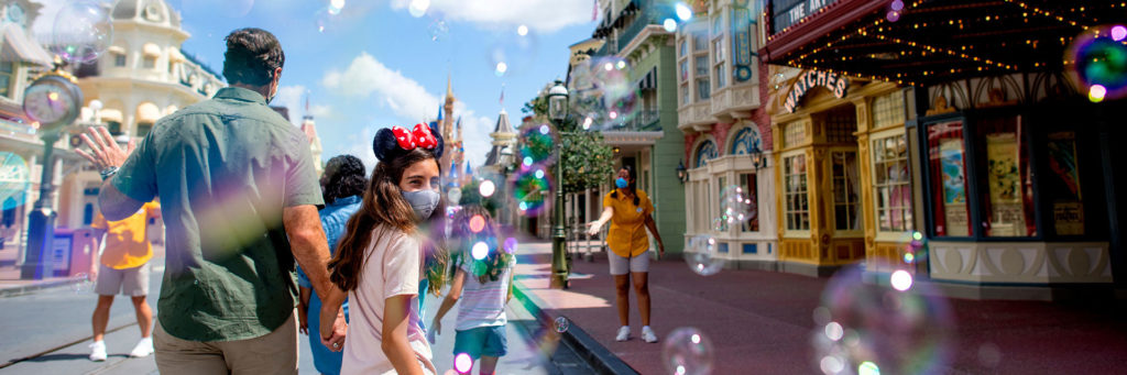 Family Wearing Masks Walks Into Walt Disney World’s Magic Kingdom Amid A Flurry Of Bubbles.