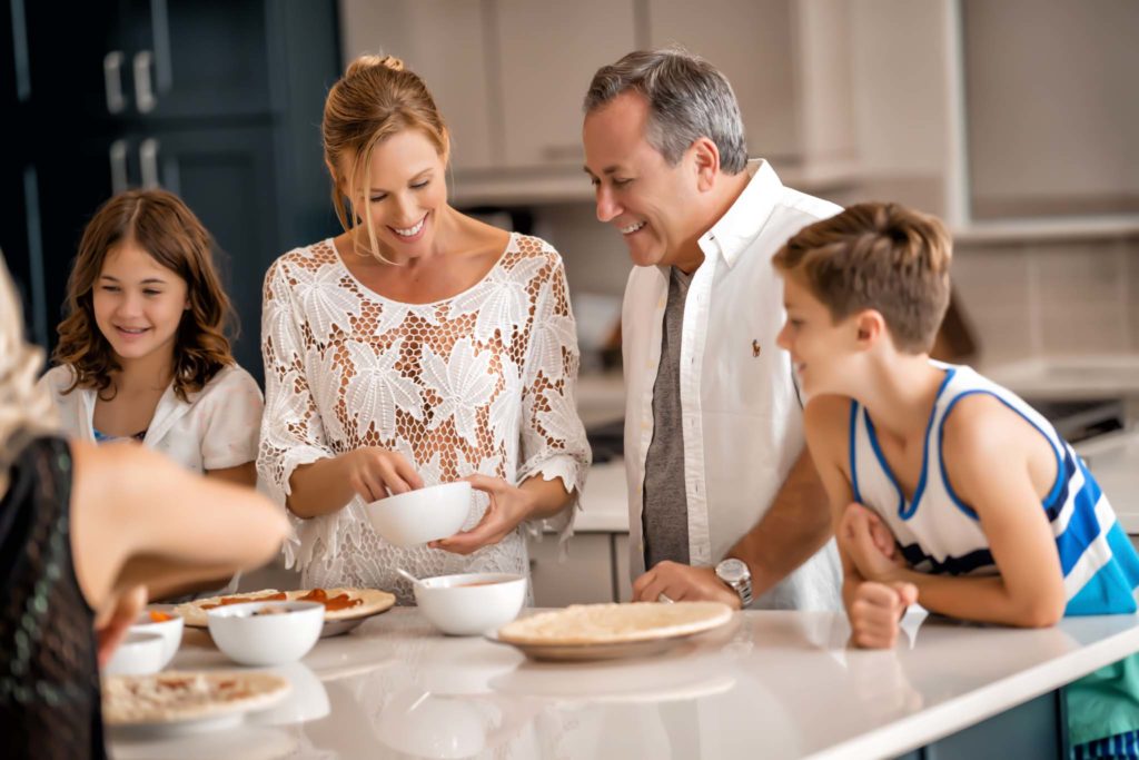 La familia se reunió para comer en la cocina de su residencia Spectrum Resort Orlando Resort durante una reunión familiar.