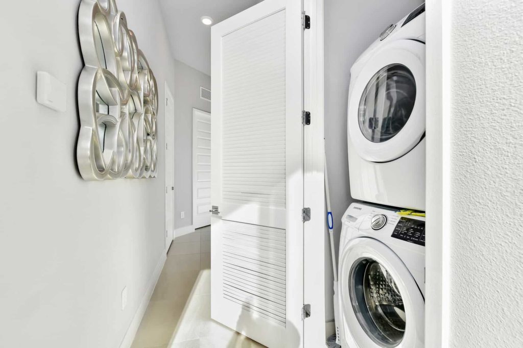 Cuarto de lavado con lavadora y secadora apiladas: Condominio de 4 habitaciones