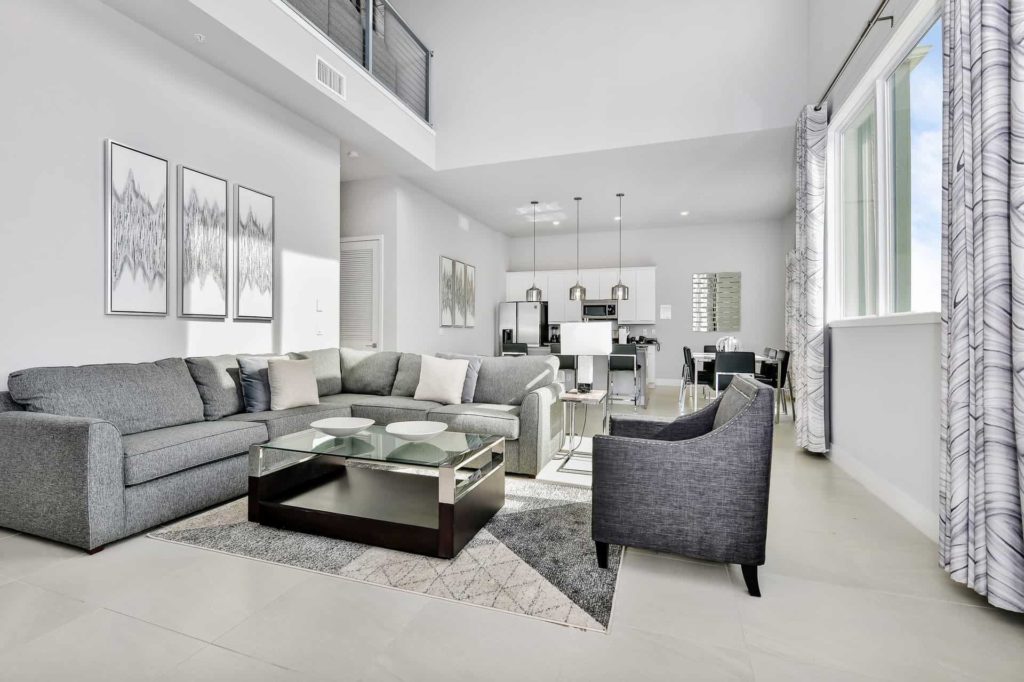 Living room with sectional sofa, ottoman, and armchair: 4 Bedroom Condo