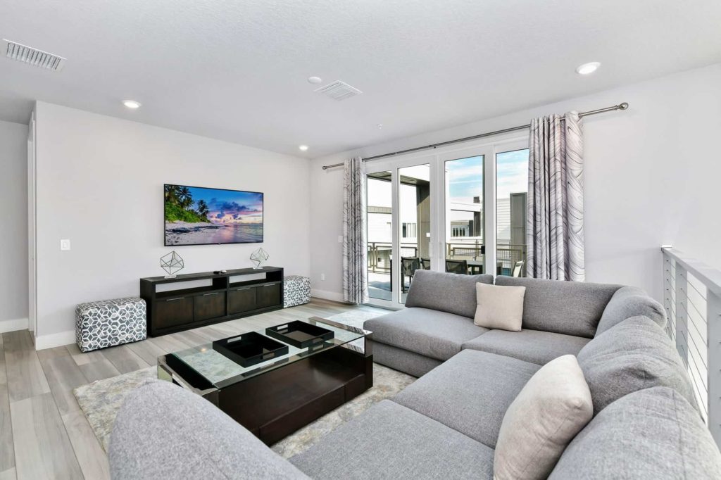 Upper-floor loft with sectional sofa and wall-mounted TV: 4 Bedroom Condo