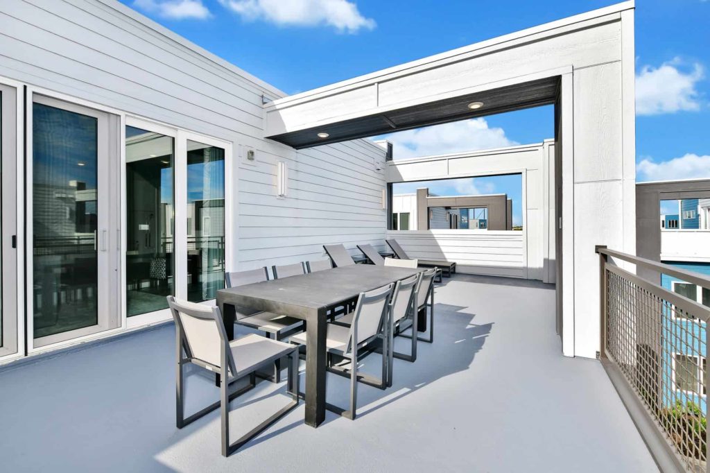 Upper-floor outdoor patio with dining table and sliding door to indoor loft: 4 Bedroom Condo