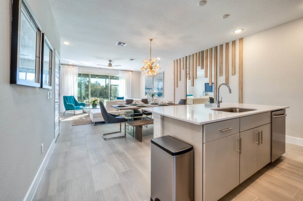Kitchen, dining, and living areas with island sink, dining table, and sectional sofa: 3 Bedroom Townhome