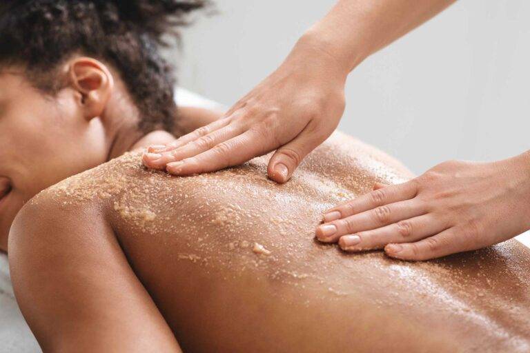 Self-Care: Woman receiving a skin scrub treatment on her back at a spa