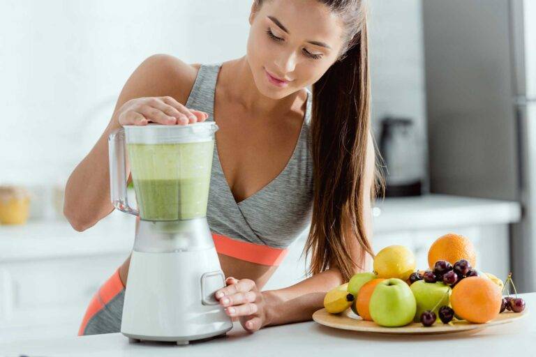 Young athletic woman blending a smoothie