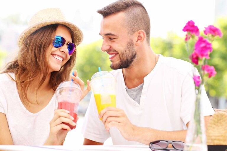 Happy couple enjoying smoothies from a cafe