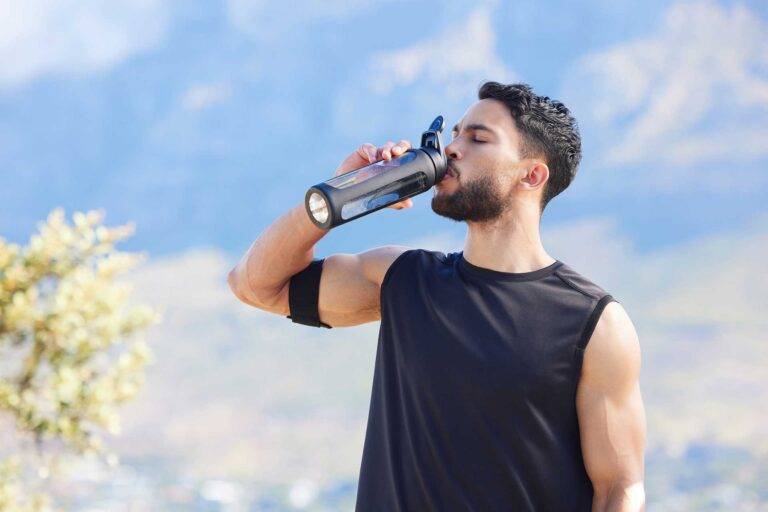 Man drinking from a water bottle after a workout