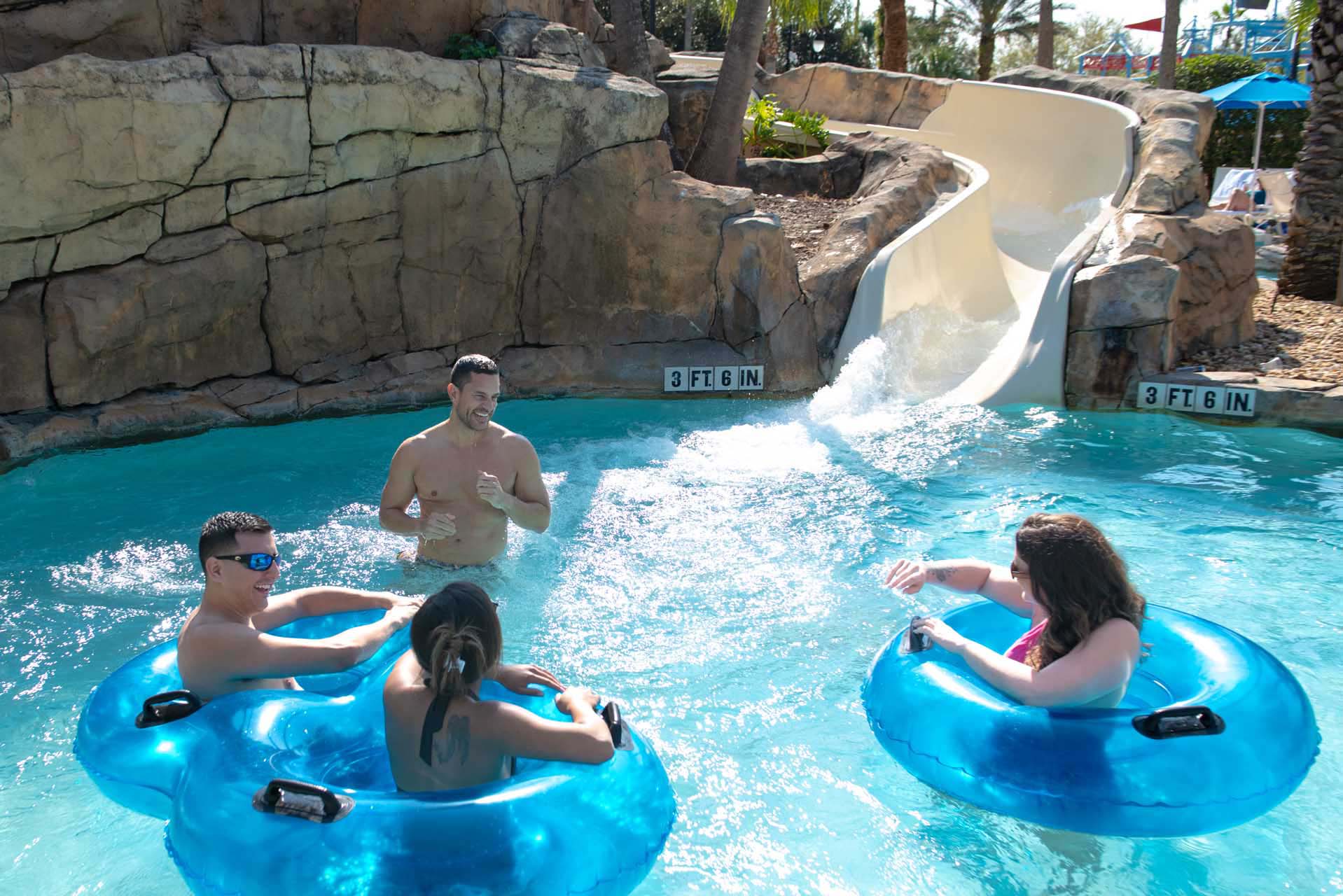 Couples hanging out in the pool at the bottom of the water slide at the Reunion Resort Water Park