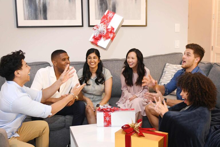 Group of friends tossing a wrapped Christmas Present in their Spectrum Resort townhome living room