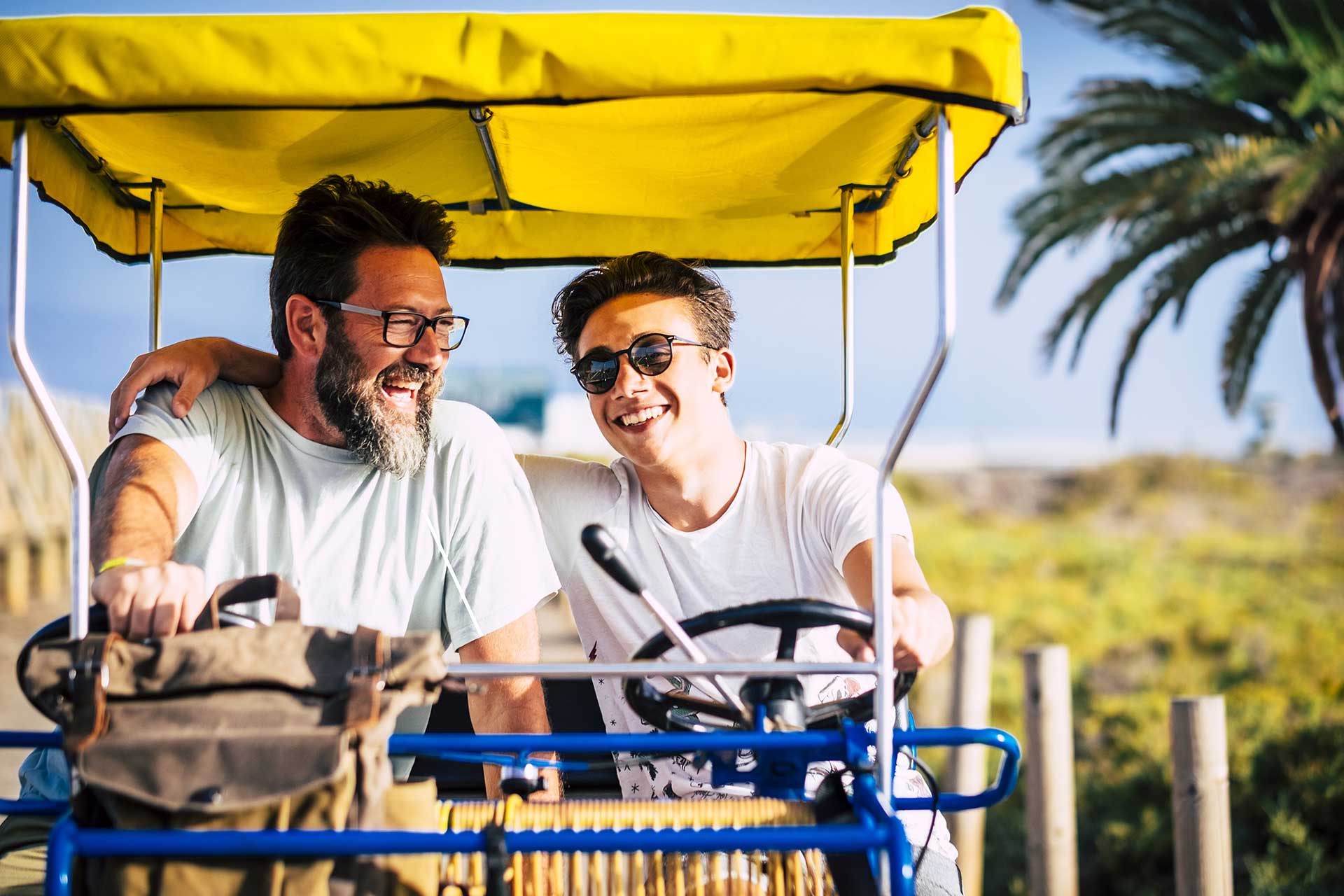 Father and son riding a surrey bike together.