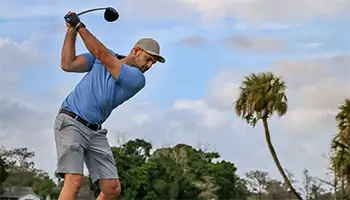 Stay and Play Offers: Golfer swinging his driver on a golf course in Florida