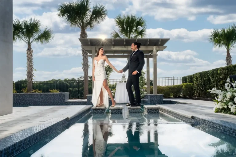 Bride and groom walking next to the pool of their private vacation home wedding reception